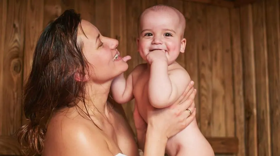 Mother holding her baby at home, where online postnatal counselling can fit around feeds and naps