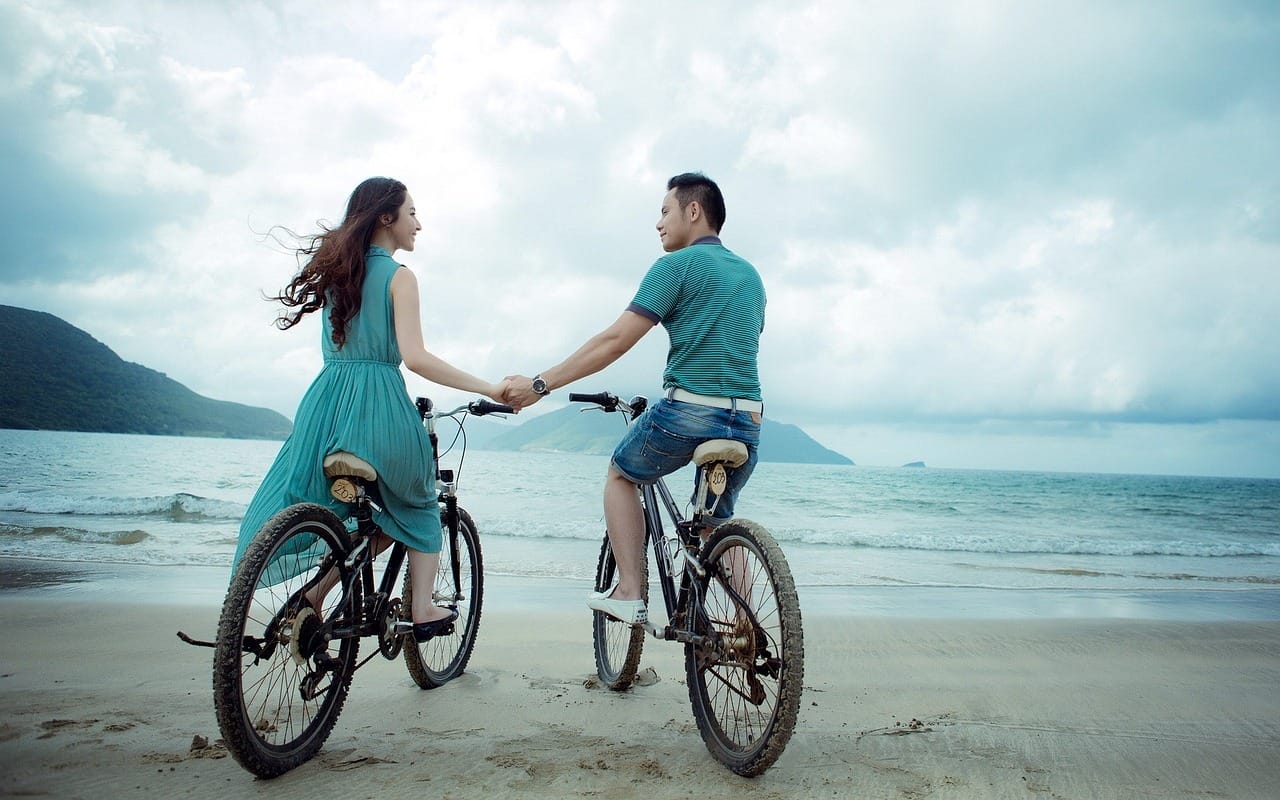 A man and woman on bikes holding hands, passion, intimacy, sex, love