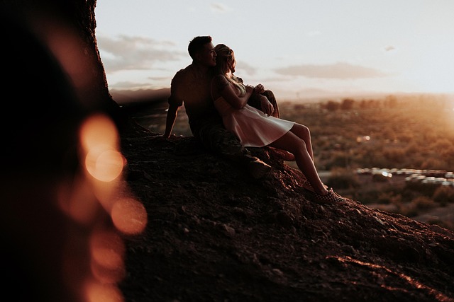 Couple leaning on each other facing the sunset, need of each other warmth